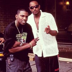 two men standing next to each other on the street