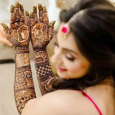 a woman holding up her hands with henna designs on it's arms and arm