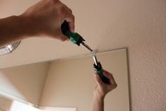 a person is brushing their teeth in front of a mirror and holding a toothbrush