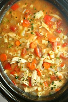 a pot filled with pasta and carrots on top of a stove