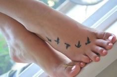 a black and white photo of a person's foot with birds on it