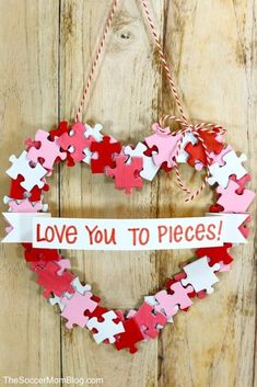 a heart shaped puzzle hanging on a wooden wall with the words love you to pieces