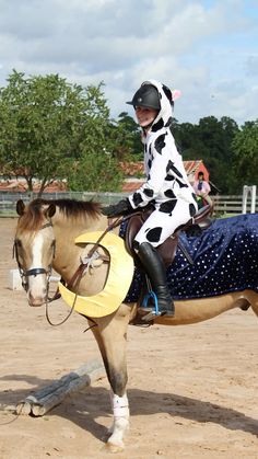 a woman dressed as a cowgirl riding a horse