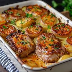 a casserole dish with meat, potatoes and vegetables in it on a table