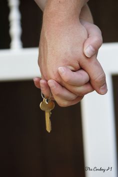 a person holding the hand of another person with a key