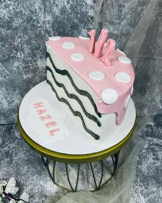 a pink and white cake sitting on top of a table