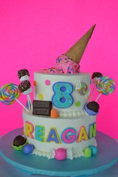 a birthday cake decorated with candy, lollipops and an ice cream cone