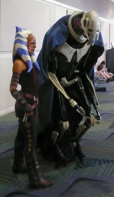 two cosplays dressed up as darth vader and droid in an airport lobby