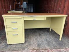 an old yellow desk with three drawers