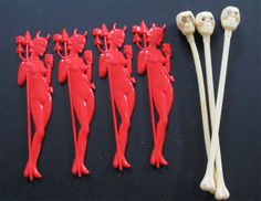 seven red devil dolls are lined up next to each other with skeleton heads on them