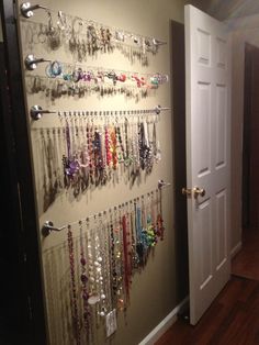 a wall mounted jewelry rack filled with lots of necklaces