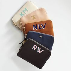 four personalized purses sitting next to each other on top of a white surface