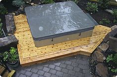 a hot tub sitting on top of a wooden platform