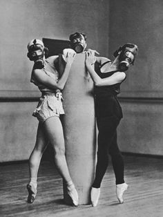 two women in costumes are holding up a surfboard while another woman stands next to them