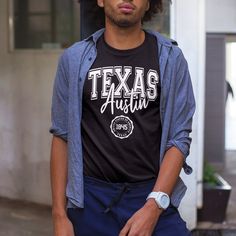 oducing the "Austin Texas United States Of America 1845" t-shirt by Kooskadoo – a stylish homage to the Lone Star State and the vibrant city of Austin! Crafted from premium Bella-Canvas fabric, this unisex tee combines comfort and quality, ensuring you'll look and feel great no matter where your adventures take you. With its sleek design and timeless appeal, it's the perfect addition to any wardrobe. Celebrate the rich history and unique culture of Austin, Texas, with this eye-catching t-shirt. Fan Merchandise Relaxed Fit T-shirt With Lettering, Black T-shirt With Lettering For Fans, Black Fan Apparel T-shirt With Lettering, Crew Neck T-shirt With Lettering For College, Casual Fan Merchandise T-shirt With Lettering, Fan Merchandise T-shirt With Lettering And Short Sleeves, College Fan Apparel T-shirt With Lettering, Fan Merchandise Short Sleeve T-shirt With Lettering, Texas Shirt