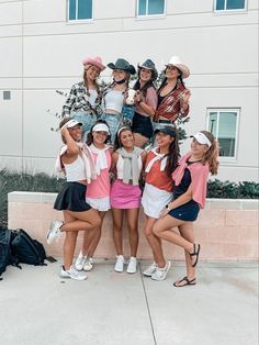 a group of young women standing next to each other in front of a white building