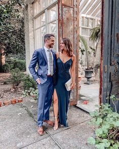 a man and woman standing next to each other in front of an open glass door