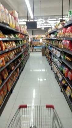 an empty shopping cart in a grocery store aisle