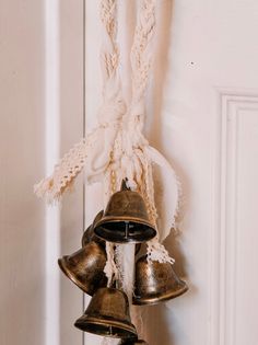 three bells hanging from the side of a white door