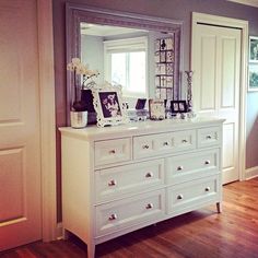 a white dresser and mirror in a room