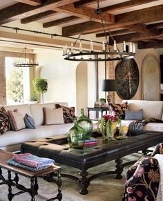 a living room filled with lots of furniture next to a fire place and chandelier