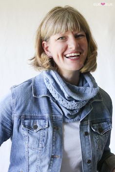 a woman wearing a denim jacket and scarf