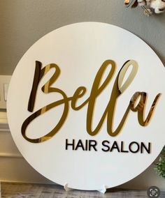 a sign that says belu hair salon on the side of a wall next to a potted plant