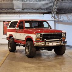 a red and white truck parked in a garage