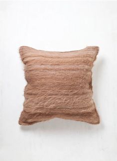 a brown pillow sitting on top of a white wall