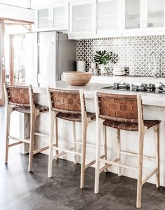 a kitchen with two stools and a center island in the middle of the room