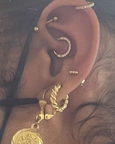 a close up of a person with ear piercings on their ears and behind the ear