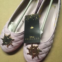 a pair of pink shoes with gold stars on them and a princess book in the middle