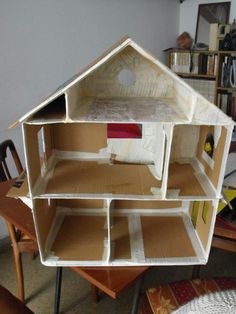 a doll house made out of cardboard sitting on top of a table