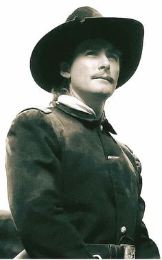 an old photo of a woman wearing a hat and coat with her hand on her hip