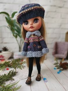 a doll is wearing a hat and coat