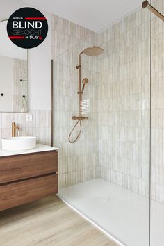 a bathroom with a shower, sink and wooden cabinet in the corner is featured for blind light