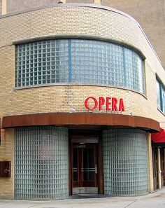 an old brick building with glass doors and a sign that says opera on the front