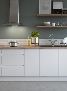 a kitchen with white cabinets and gray walls