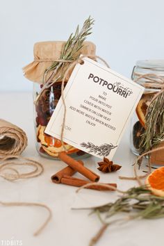 a jar filled with cinnamon, orange slices and spices next to twine of twine