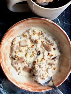 a bowl of oatmeal next to a cup of coffee