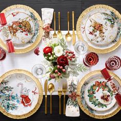 the table is set for christmas dinner with gold trimmings