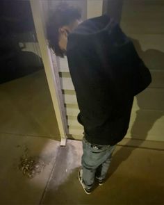 a young boy standing in front of a door