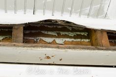 an old window with moldy paint on the windowsill and wood slats behind it