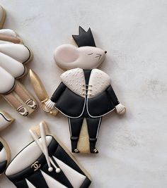 decorated cookies in the shape of cats and mice with black and white designs on them