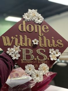 a maroon graduation cap with gold lettering and flowers on it that says, dope with this bss bachelor of science