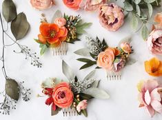 flowers and greenery arranged on a white surface