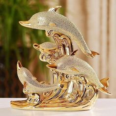 three gold dolphins on top of each other