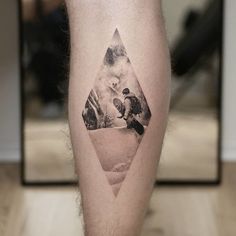 a man's leg with a triangle tattoo on it and an image of two people riding skis