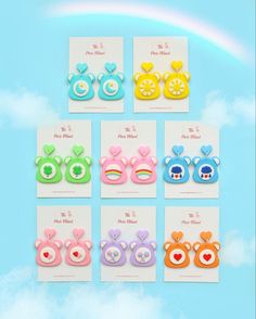 six pairs of bear ear clips in different colors and shapes on a blue background with clouds