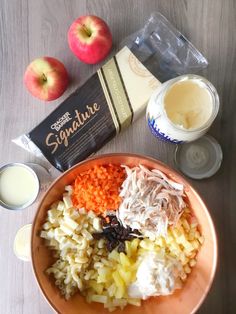 an orange bowl filled with rice, fruit and milk next to some yogurt